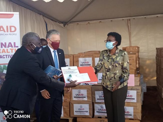 Health Minister Aceng receiving COVID-19 tools donated by USAID