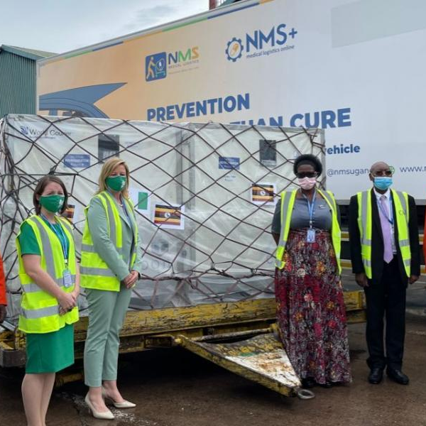 Nicole McHugh, the Deputy Head of Mission Embassy of Ireland ( Centre) hands over the doses to Margaret Muhanga, the minister of state for PHC at the Entebbe Airport as other government and NMS officials look on
