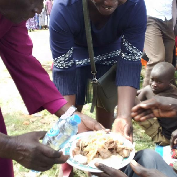 Rtd Bishopof Kitgum McLoed Baker Ochola serves one of the children suffering with nodding syndrome