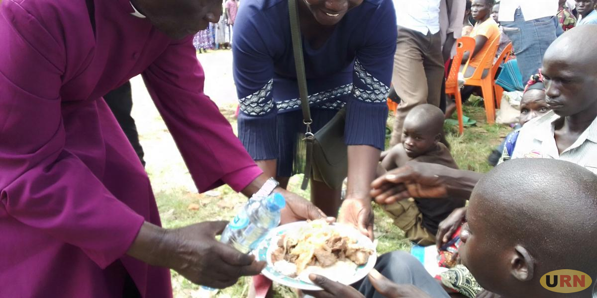 Rtd Bishopof Kitgum McLoed Baker Ochola serves one of the children suffering with nodding syndrome