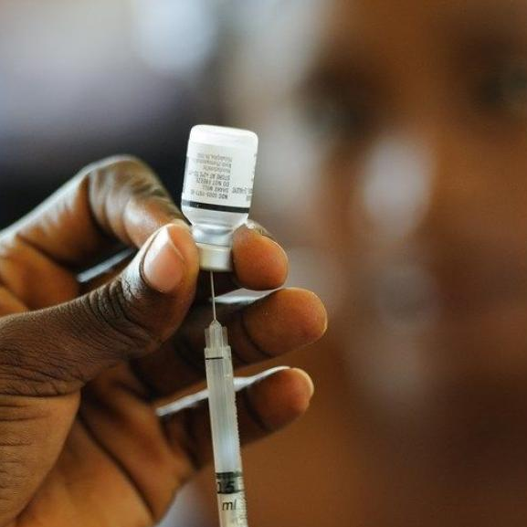 A nurse fills a syringe with a vaccine