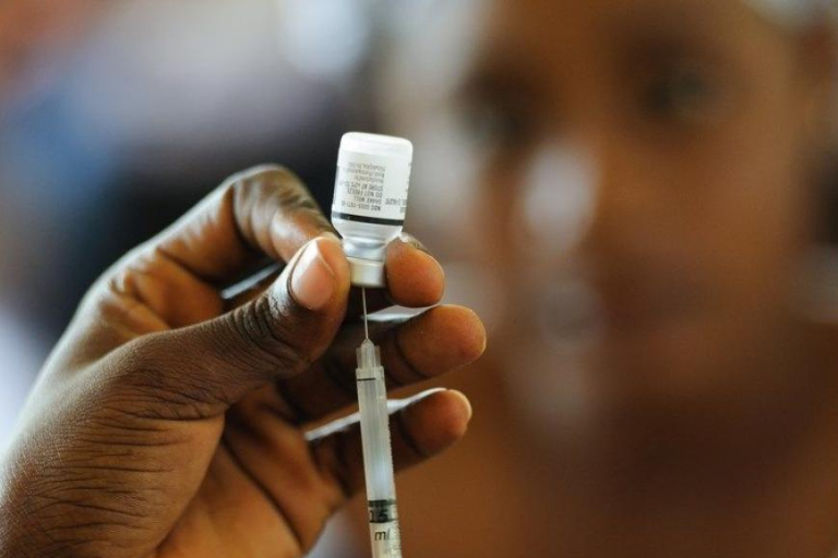 A nurse fills a syringe with a vaccine